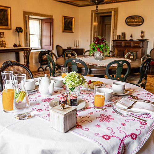 Desayuno de lujo en el hotel: Axis: Corporate servido en una mesa elegantemente decorada con flores y fruta.