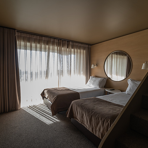Dois quartos de hotel modernos com camas, janelas e escadas. Axis: Corporate
