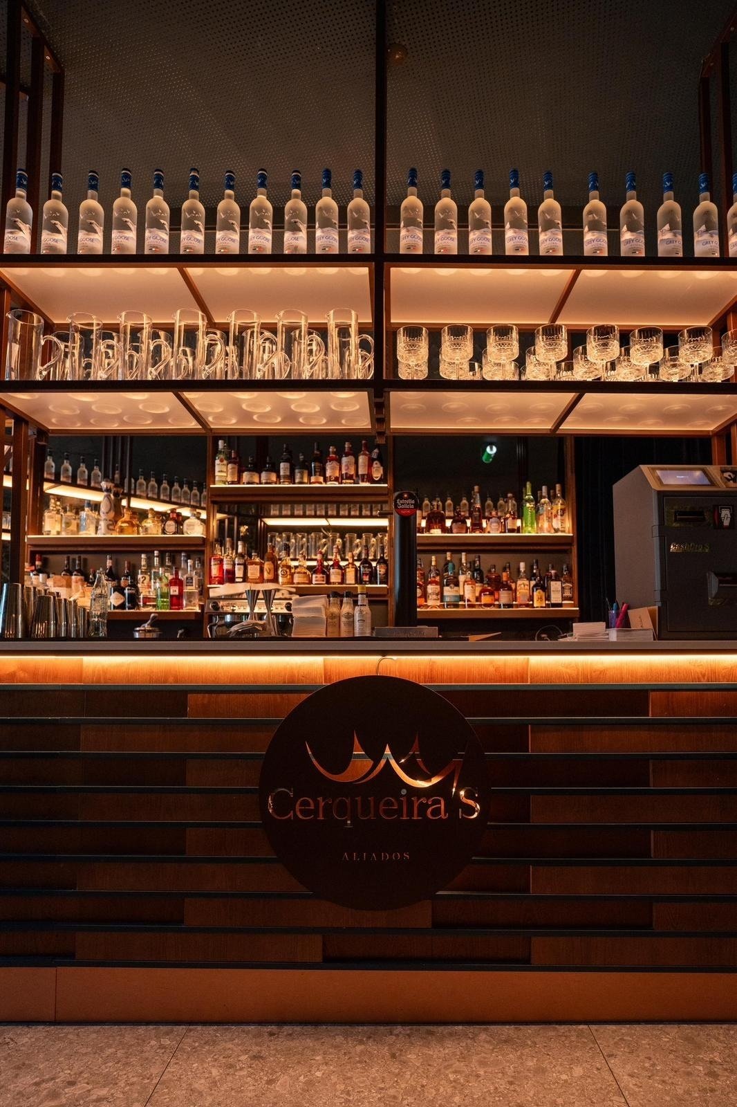 la barra de cerqueira 's está llena de botellas y vasos