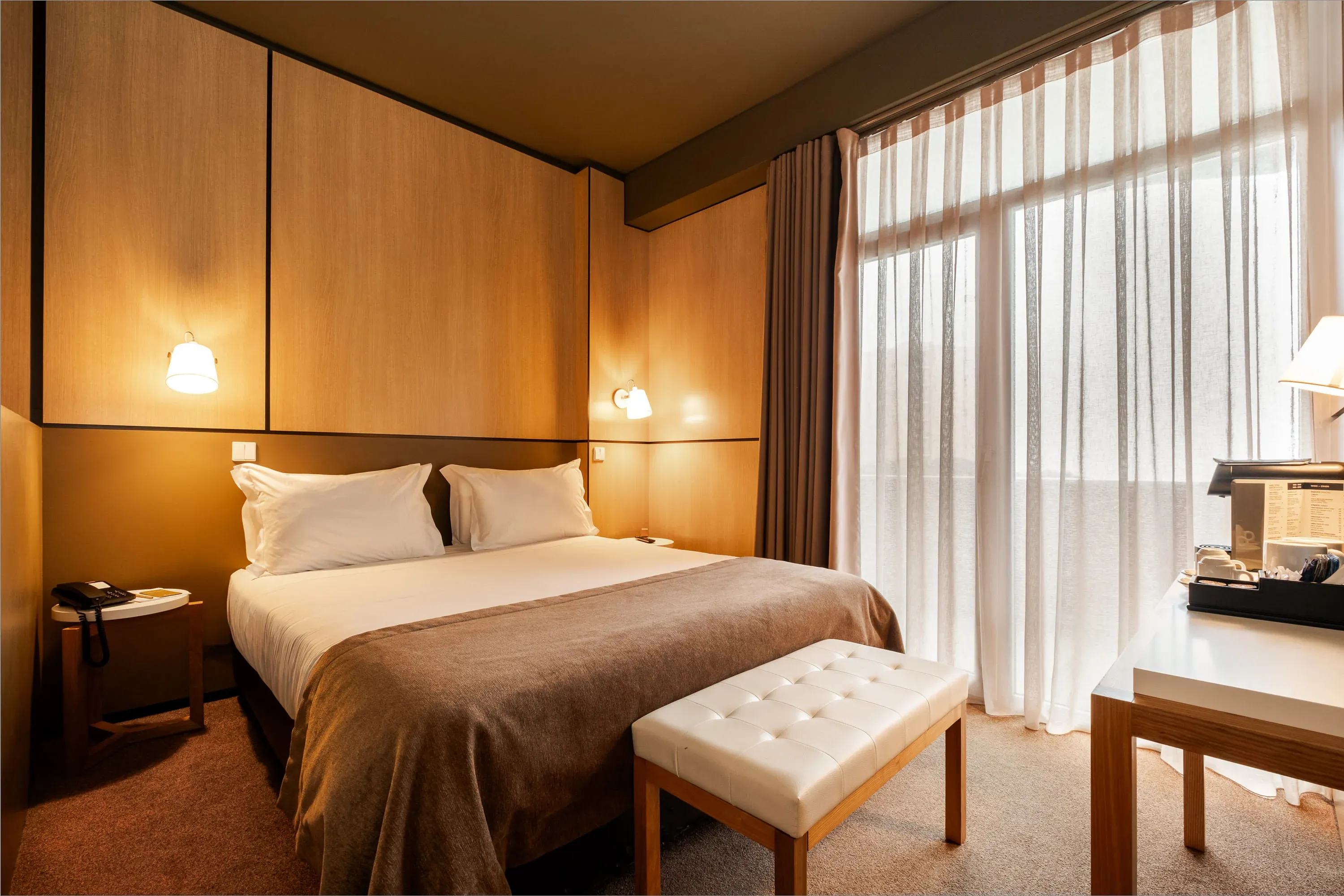 Quarto de hotel confortável com cama king-size, decoração em madeira e Vermar | Axis Hotéis & Golfe | Website Oficial.