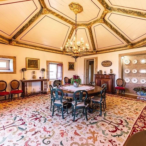 a dining room with a table and chairs and plates on the wall
