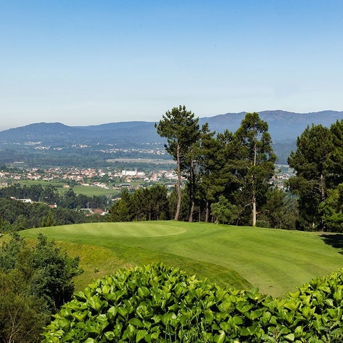 a view of a golf course with mountains in the background
