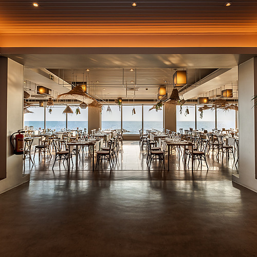 Axis: Corporate: Comedor elegante con vistas al mar y mesas puestas para una experiencia gastronómica inolvidable.