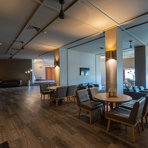 Lounge sofisticada com assentos confortáveis e mesas, perfeita para relaxar ou para Axis: Corporate em um ambiente acolhedor.