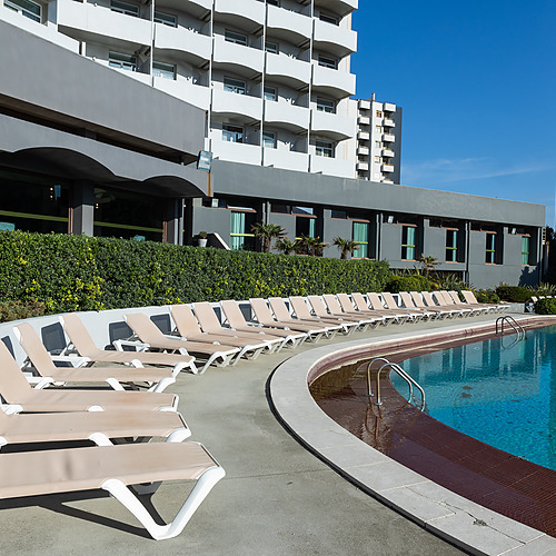 Deck e piscina de hotel com espreguiçadeiras. Axis: Corporate