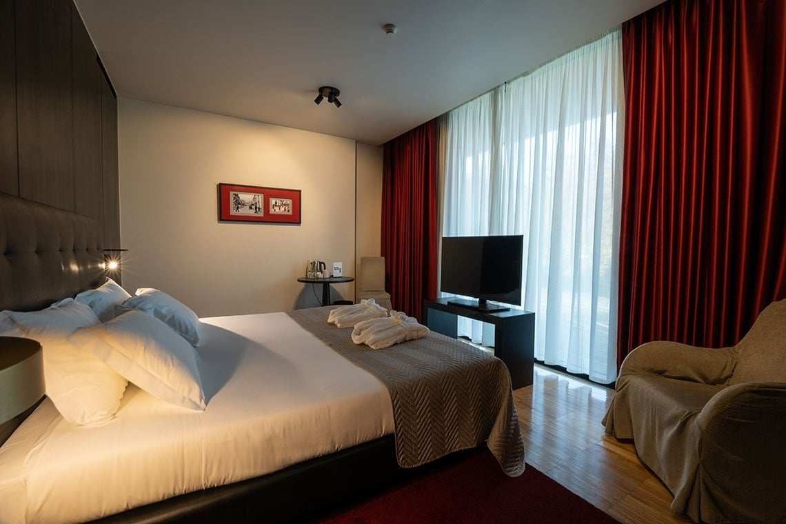 a hotel room with a large bed and a television