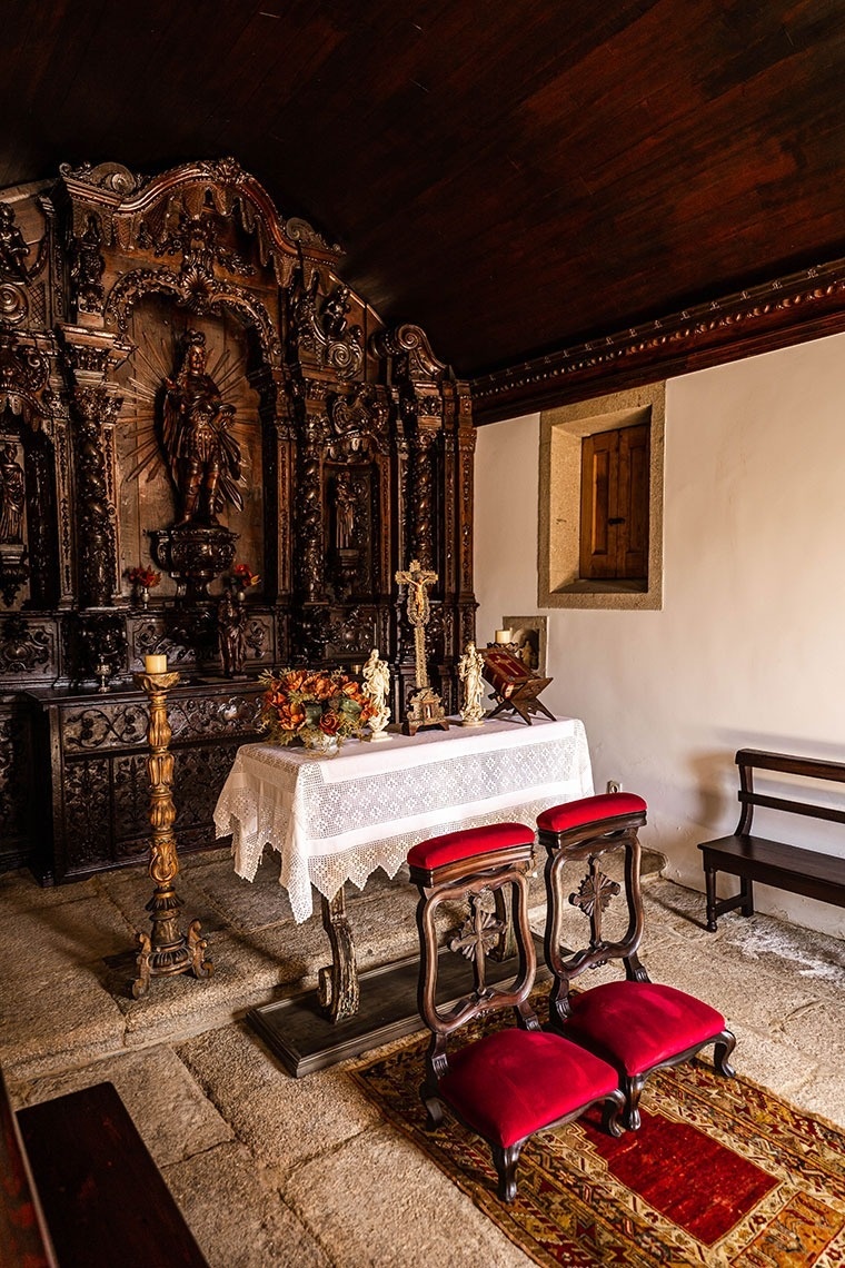 um altar em uma igreja com duas cadeiras vermelhas