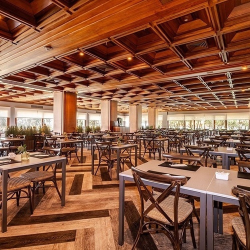 a restaurant with tables and chairs and a wooden ceiling