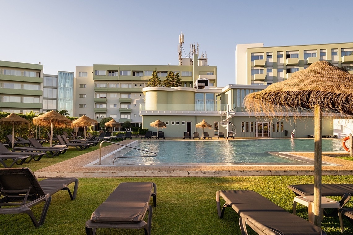 uma grande piscina cercada por cadeiras e guarda-sóis
