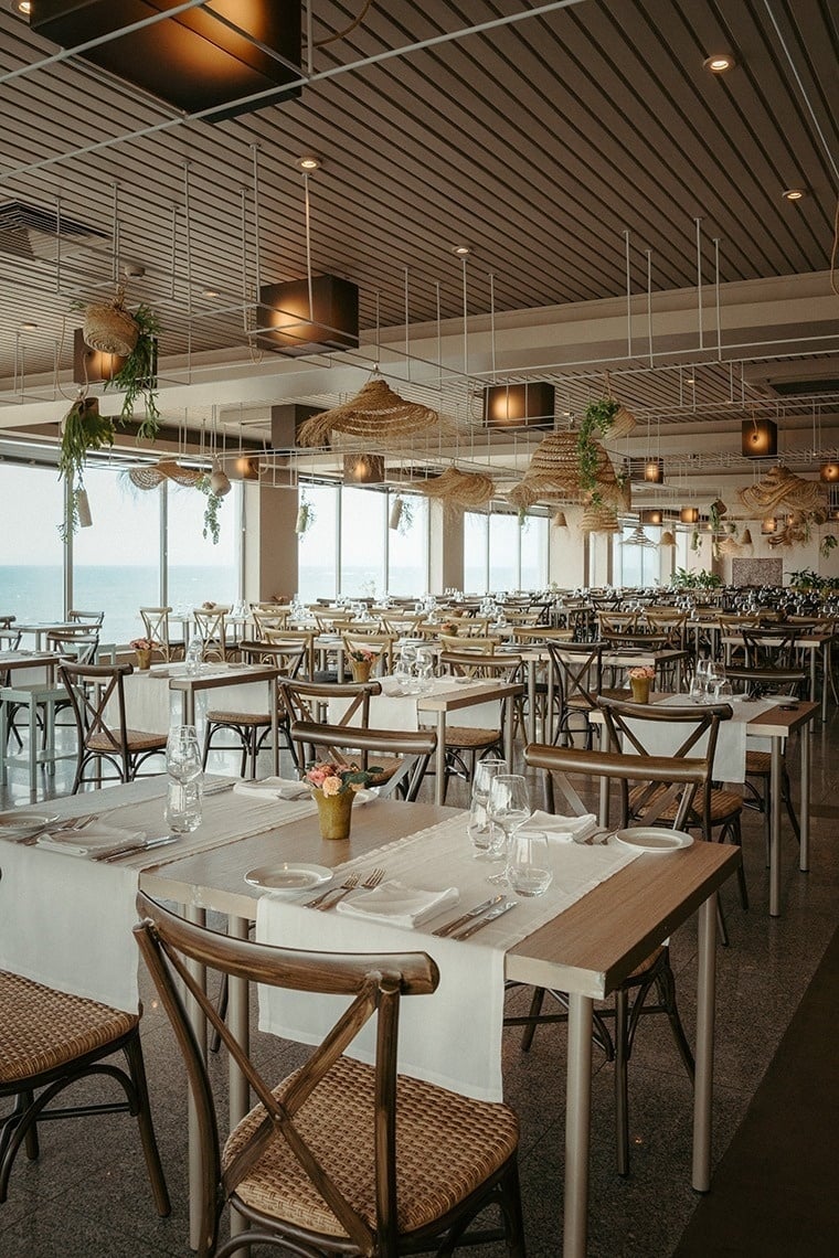 uma grande sala de jantar com muitas mesas e cadeiras