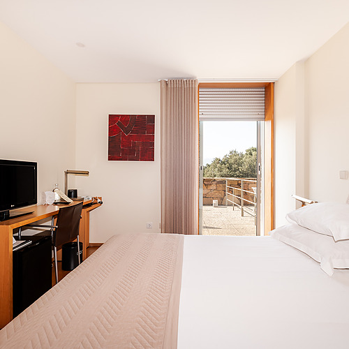 Habitación doble con cama cómoda, escritorio y balcón con vistas a Axis: Corporate.