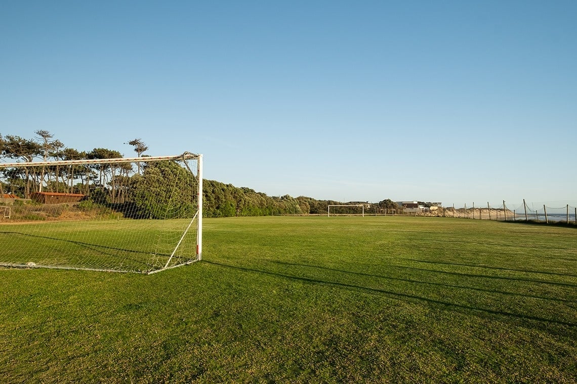 um campo de futebol com árvores ao fundo
