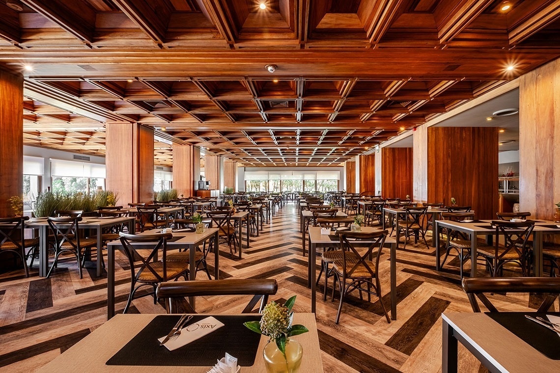 a restaurant with a wooden ceiling and tables and chairs