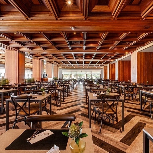 a large dining room with tables and chairs and a wooden ceiling