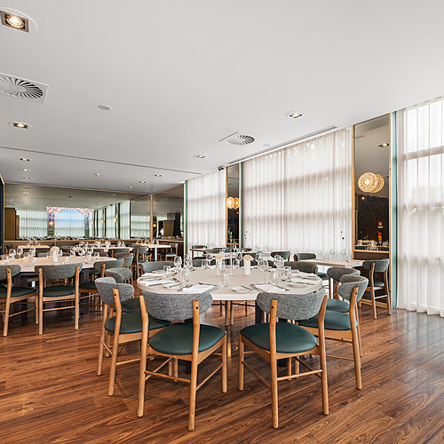 Salón de restaurante con mesas dispuestas para eventos y decoración moderna, ideal para cenas Axis: Corporate.