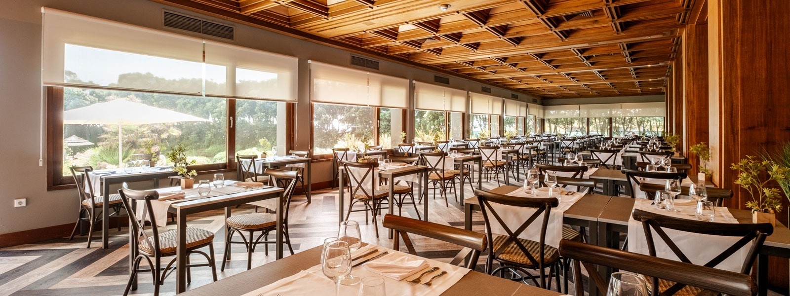 un restaurante lleno de mesas y sillas con un techo de madera