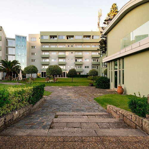 a large green building with stairs leading up to it