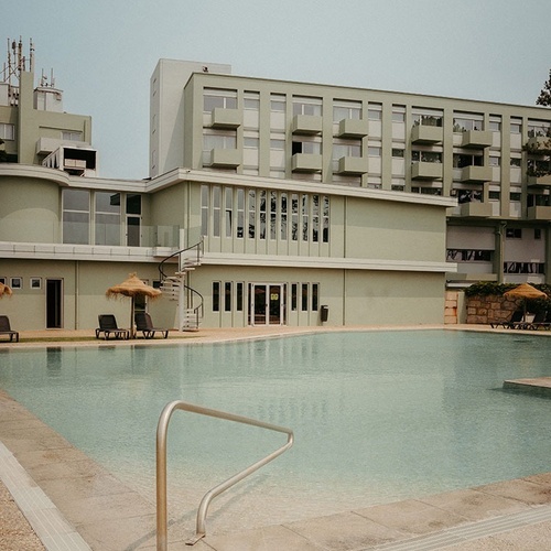 a large building with a swimming pool in front of it