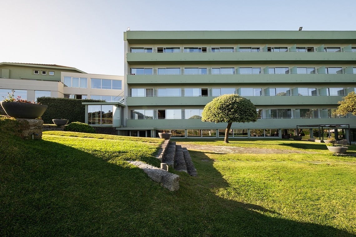 um grande prédio verde com muitas janelas