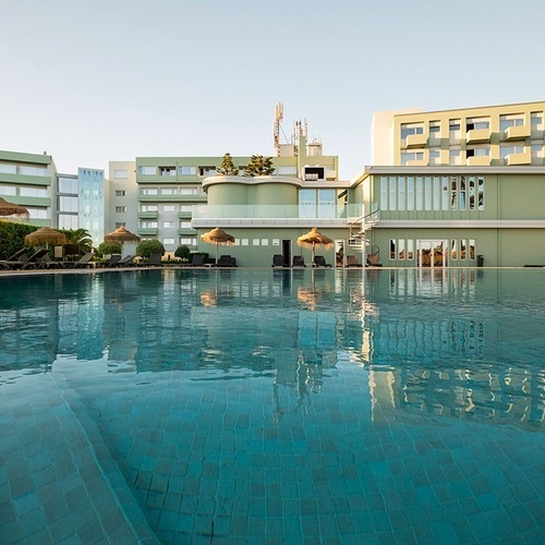 a large swimming pool in front of a hotel