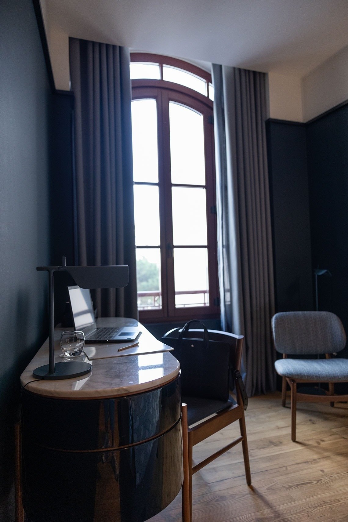 a desk with a laptop on it in front of a window