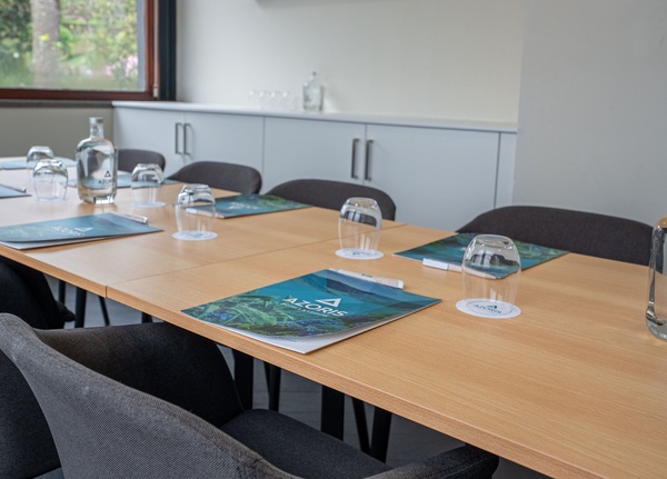 uma sala de jantar com uma longa mesa branca e cadeiras brancas