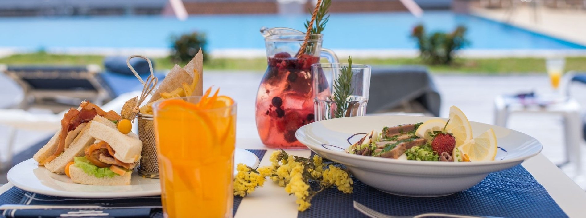 una mesa con un plato de comida y un vaso de jugo de naranja