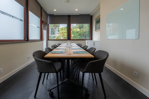 uma sala de conferências com mesas e cadeiras brancas