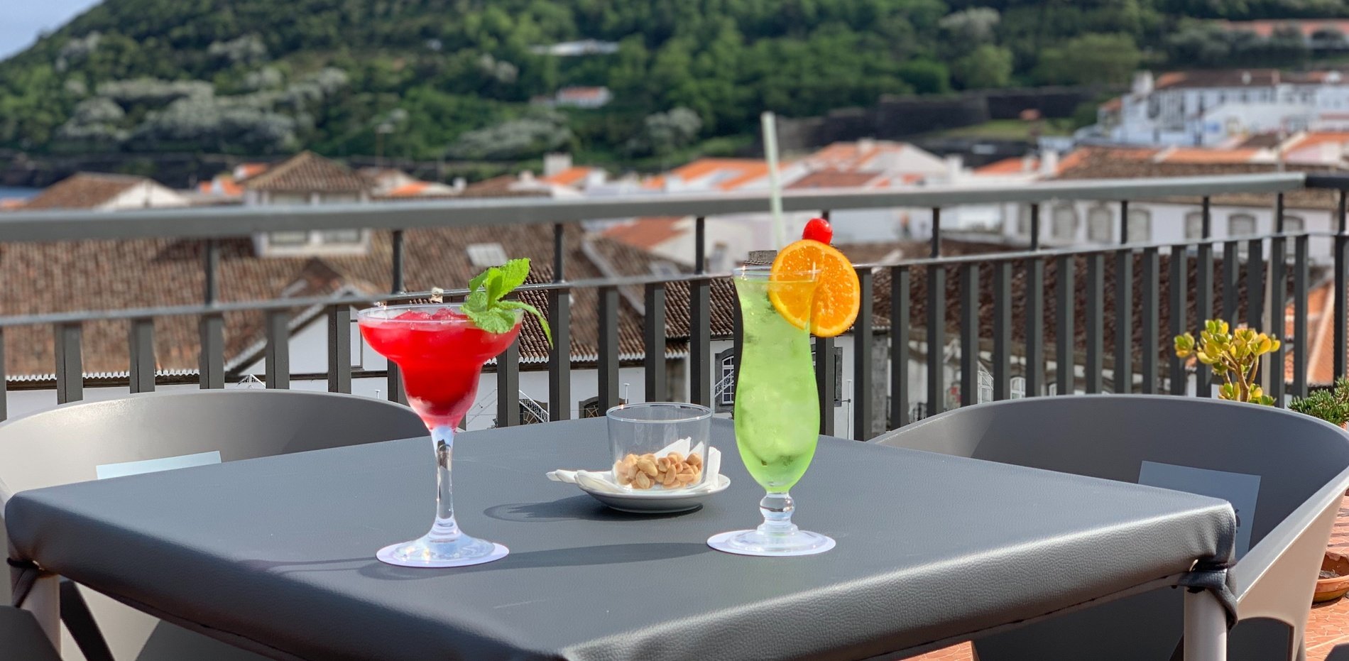 two drinks on a table with a mountain in the background