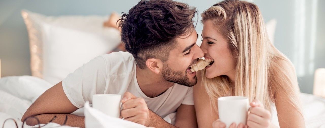 Casal em momento romântico na cama com café. Oferta Fall In Love no Azoris Faial Garden.