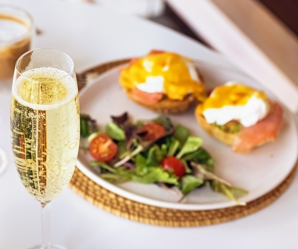 a plate of food next to a glass of champagne