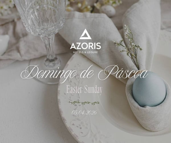Uma imagem promocional da Azoris para o Domingo de Páscoa, mostrando uma mesa elegantemente posta com um ovo azul decorativo e um copo de cristal.