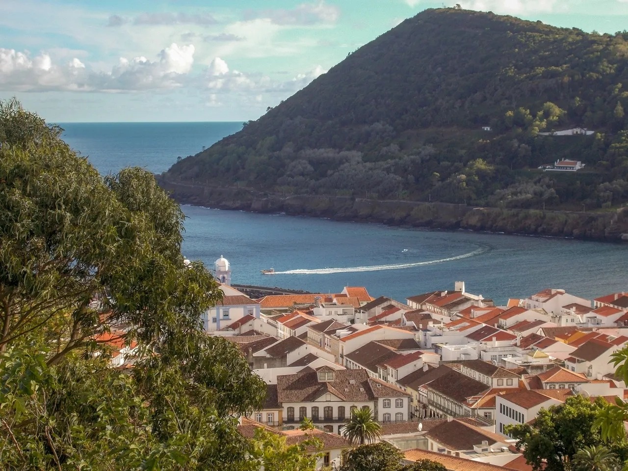 un pequeño pueblo en la costa con un barco en el océano
