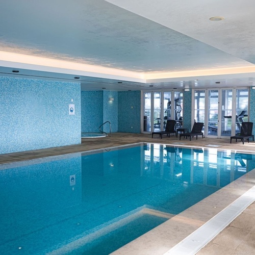 Azoris Corporativa indoor pool with lounge chairs and sea views.