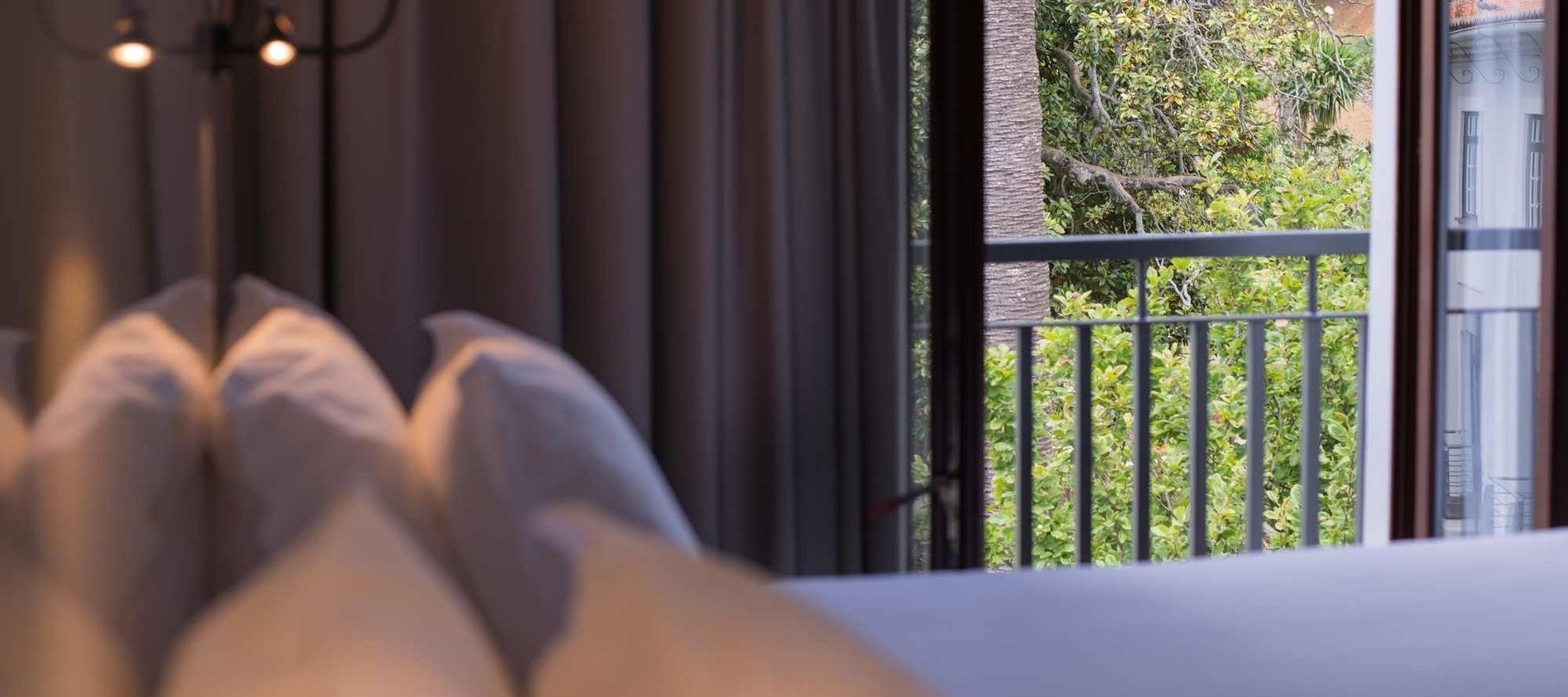 a bedroom with a view of a balcony and trees