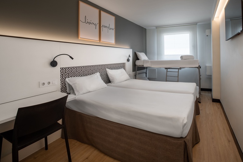 une chambre d' hôtel avec deux lits jumeaux et un bureau