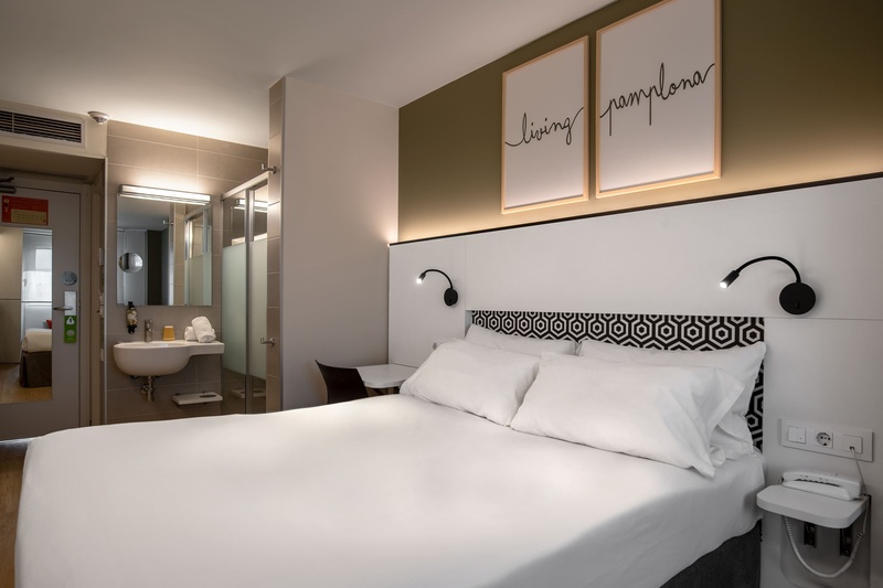 una habitación de hotel con una cama y dos cuadros que dicen 