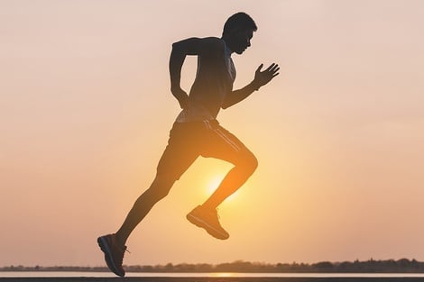 un hombre salta en el aire mientras corre al atardecer