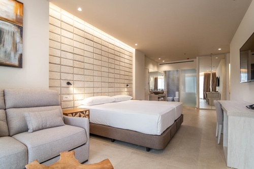 a hotel room with a large bed and a chair