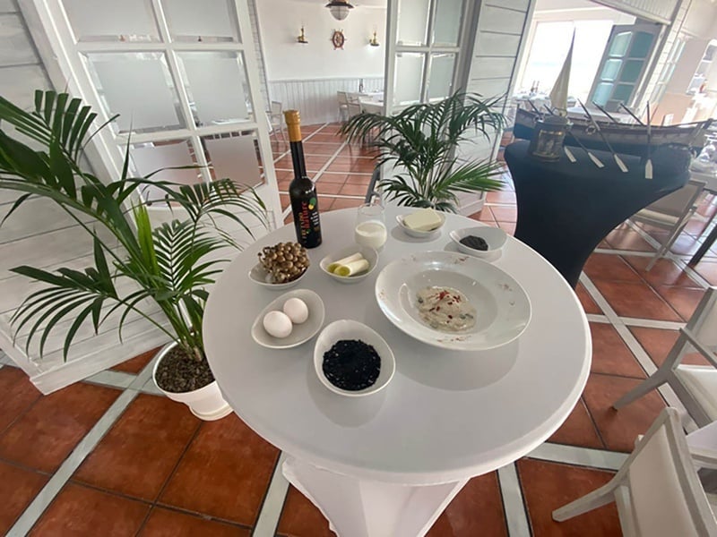 una mesa blanca con platos de comida y una botella de vino