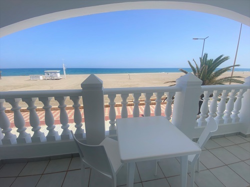 a balcony with a table and chairs overlooking the ocean
