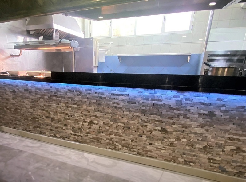 a kitchen with a brick wall and blue lights