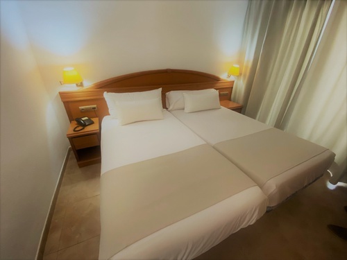 a hotel room with two beds and a phone on the nightstand