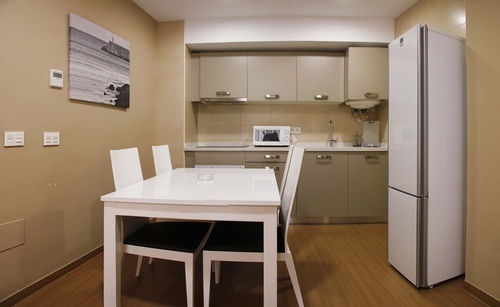 a kitchen with a table and chairs and a refrigerator