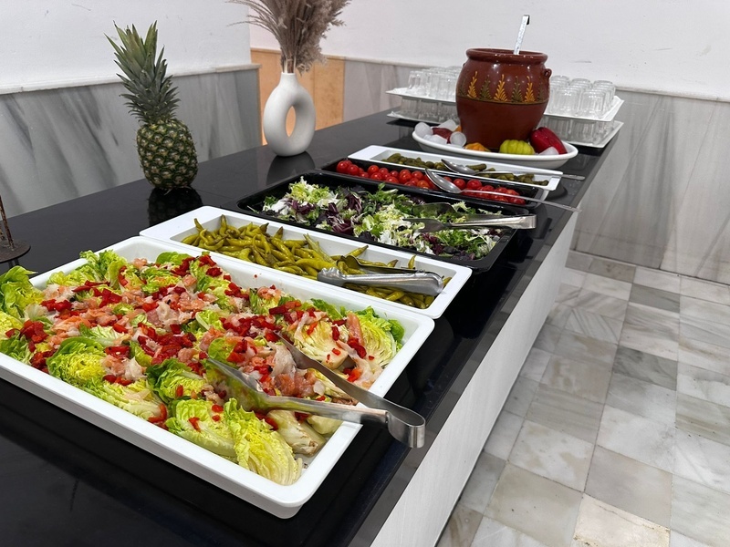 un buffet de ensaladas y verduras con una piña en el fondo