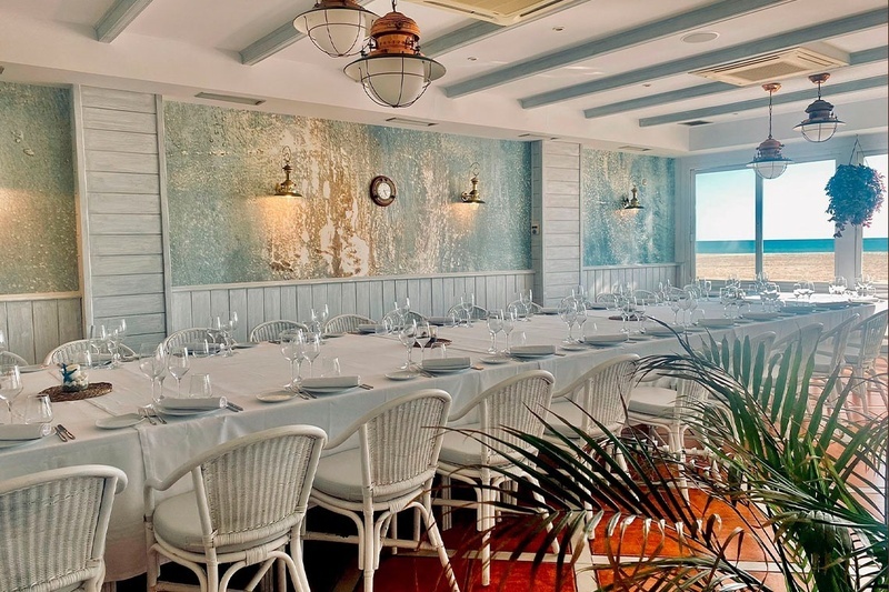 una mesa larga con platos y copas en un restaurante