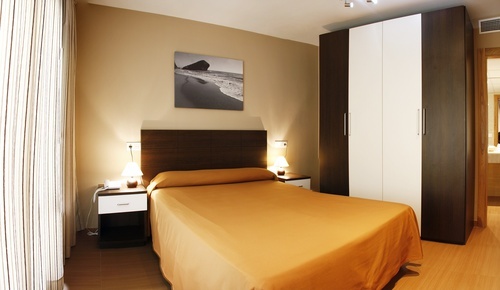 a bedroom with a painting on the wall above the bed