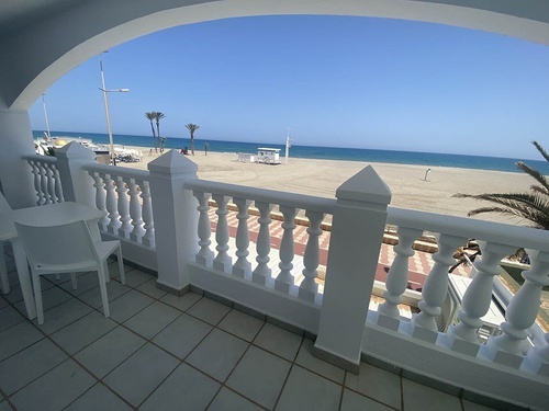 a balcony with a view of the beach and ocean