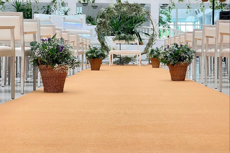 a row of chairs with wicker baskets of flowers on the floor