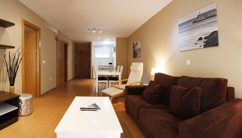 a living room with a brown couch and a white table